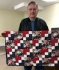 Lannie Henze holds a quilt that was made for Honor Flight Veterans. The veterans received many small tokens of appreciation. Each veteran also had mail call with letters from family and friends, along with notes from all over the country.