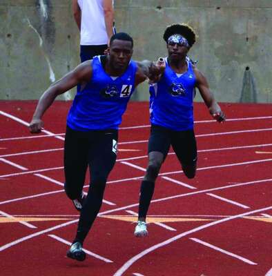 Anthony Havens, Jr., handing the baton off to Verlyn Johnson during the 4x100 meter relay.